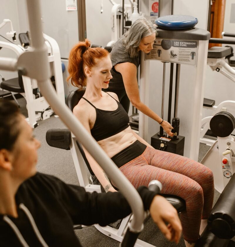 Women working out on gym equipment, promoting strength and fitness.